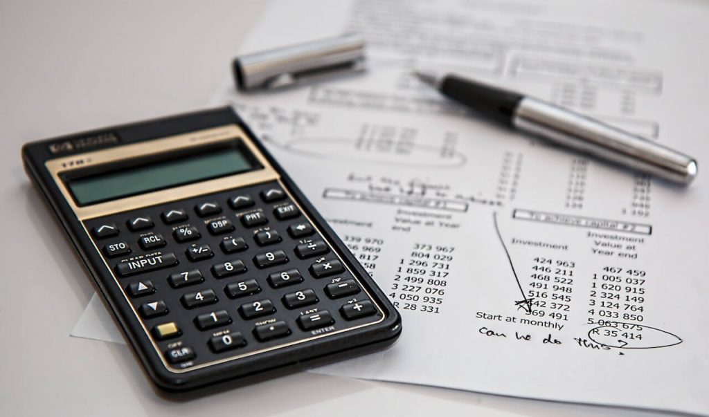 Des documents comptables avec une calculatrice et un stylo.
