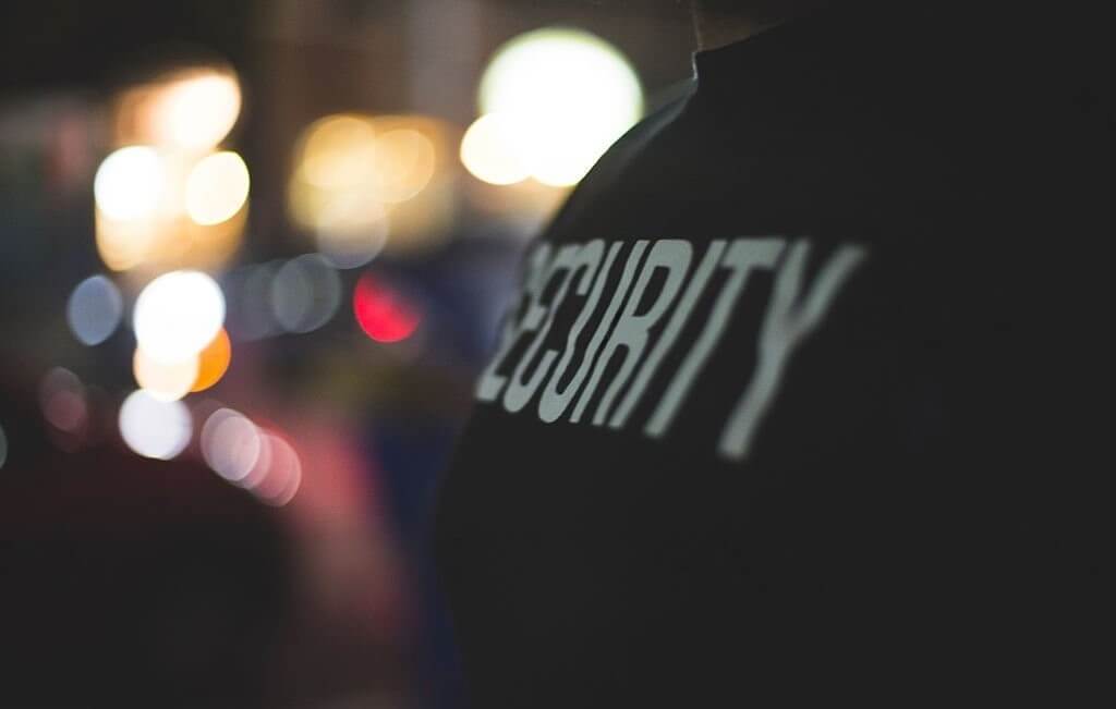 Personne portant un t-shirt noir sur lequel est écrit "security".